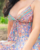 Luna Mini Dress showcasing a vibrant boho print in red, blue, and orange with a flattering V-neckline